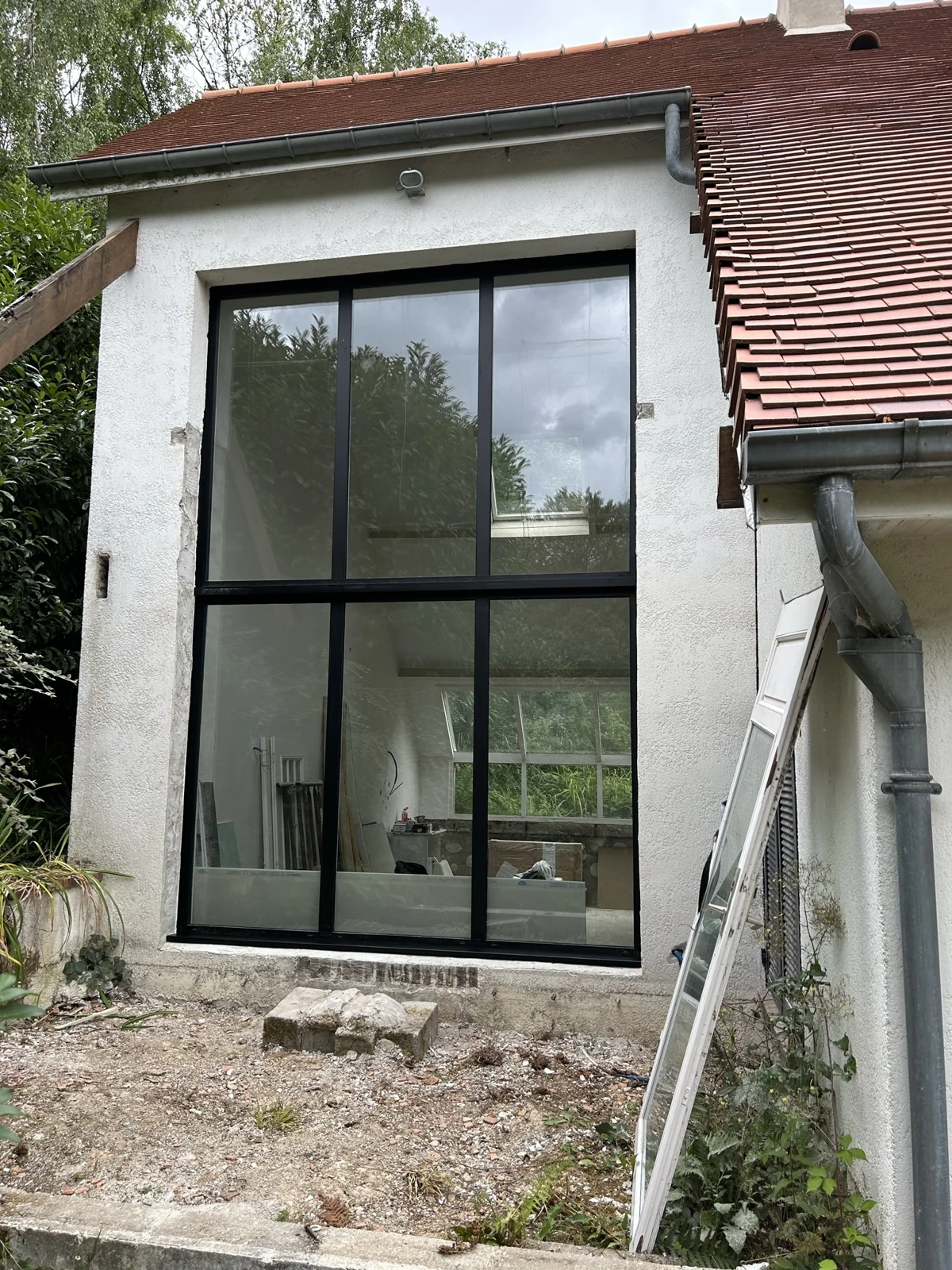 Pose d’une menuiserie vitrée de grande hauteur sur un chantier de rénovation
